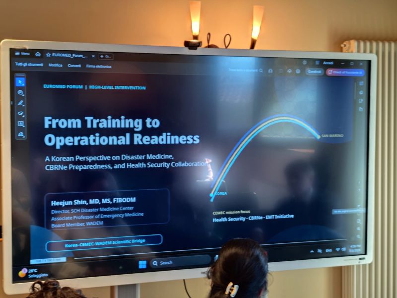 현장 모니터에 표시된 From Training to Operational Readiness 발표 표지와 발표자 표기.